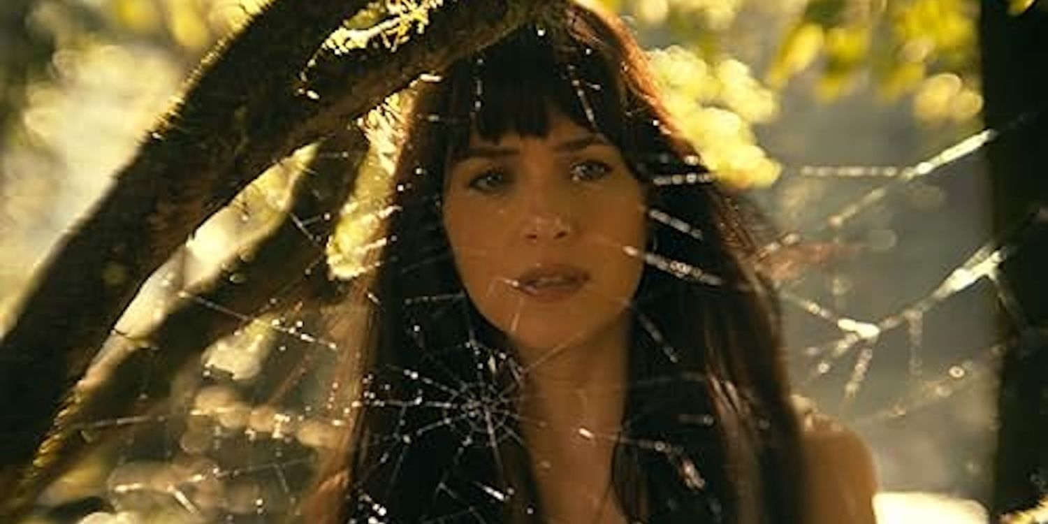 Dakota Johnson como Cassandra Webb, examinando pensativamente una telaraña en el Amazonas. 