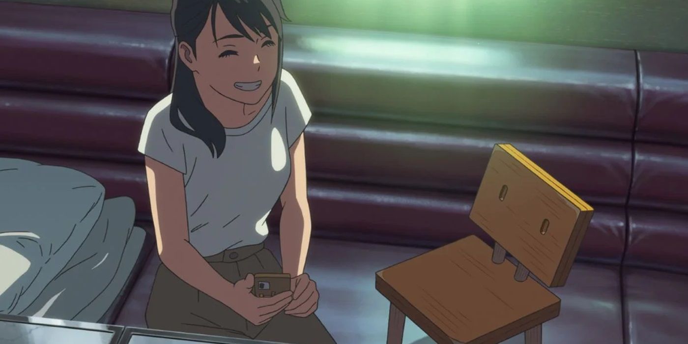 Suzume sonriéndole a Souta en forma de silla en la película de anime titular de Makoto Shinkai.