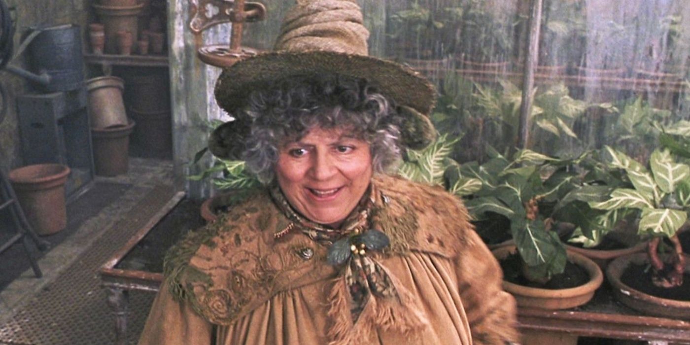 La profesora Sprout sonríe cerca de mandrágoras recién plantadas en Harry Potter y la cámara secreta