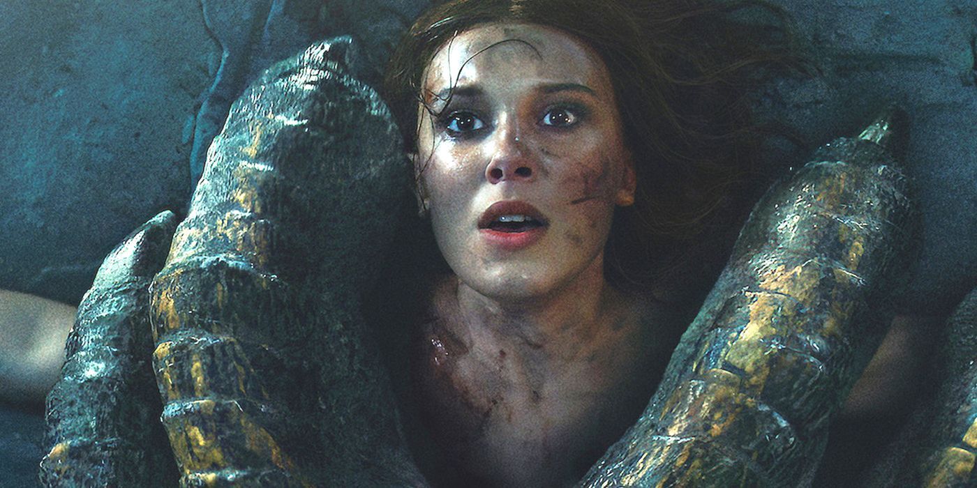 Elodie (el actor Mille Bobby Brown) está retenida bajo el pie de un dragón en la película de Netflix Damsel.